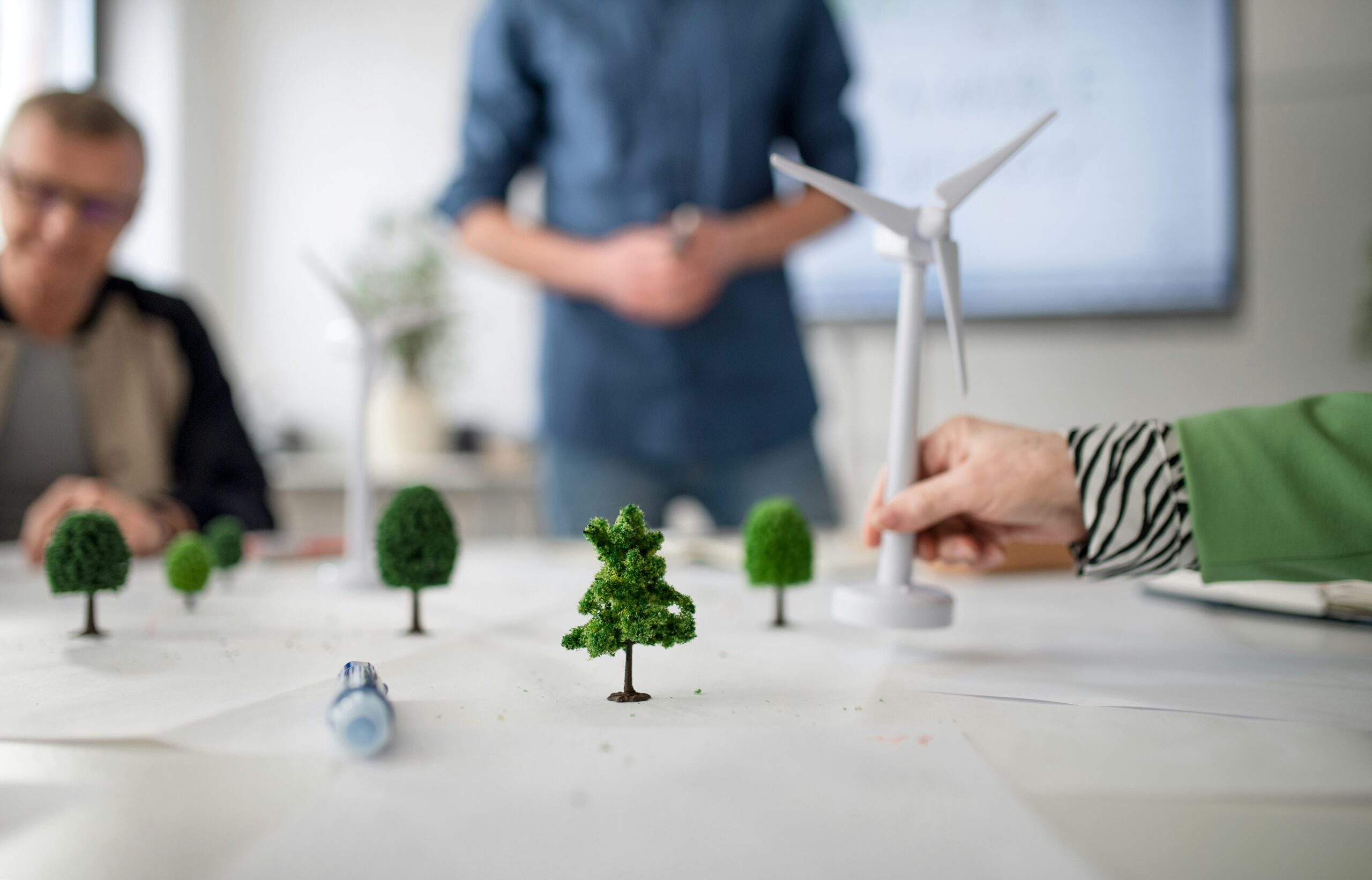 miniature trees, people in a conference room, miniature wind turbines